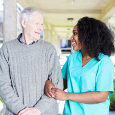 happy caregiver and senior man walking