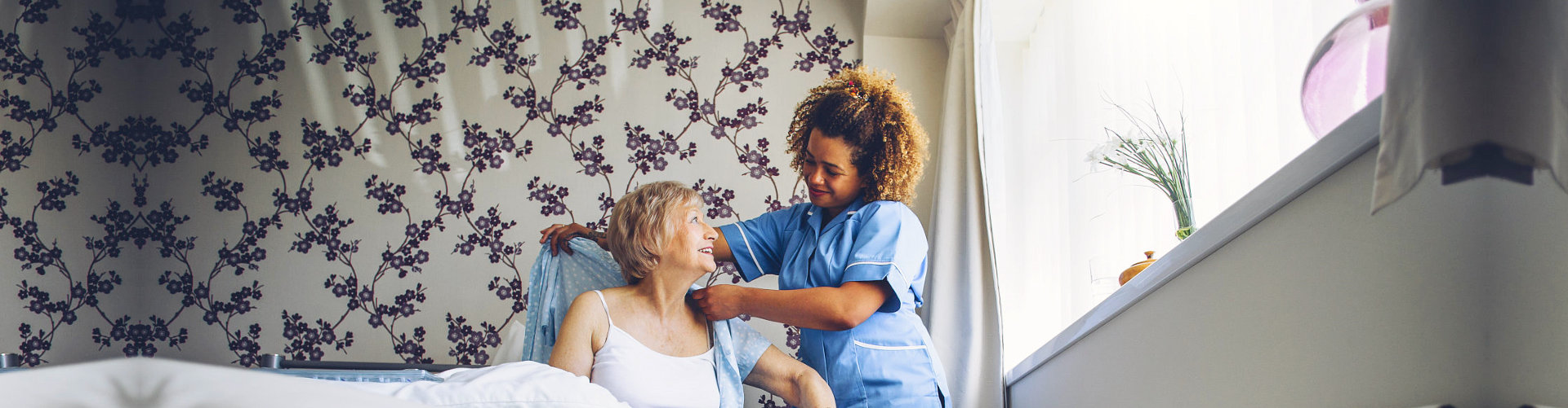 caregiver helping senior woman get dressed