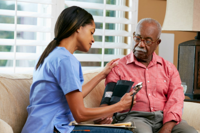 nurse checking elder man's blood pressure level